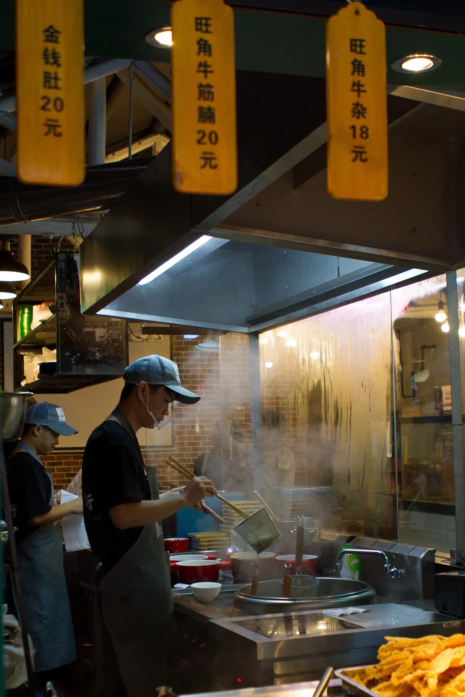 A cook preparing noodles in a Shanghai street food setting